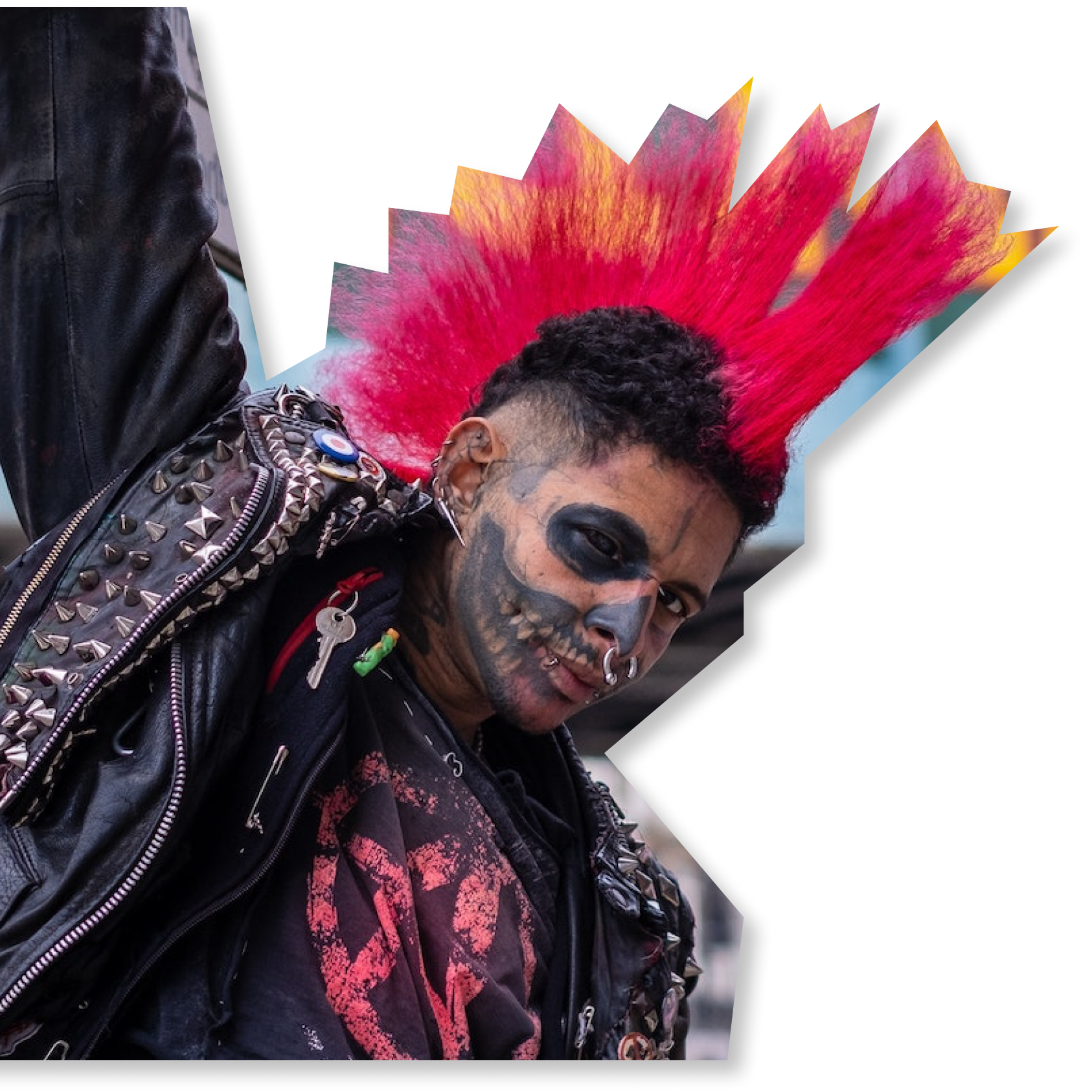 An anarchist punk with a vibrant magenta mohawk, face tattoos, and modified jacket. His shirt has the anarchist circle-A symbol.
